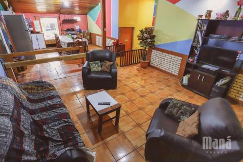 Una sala de estar con dos sofás y una mesa. en Posada Maná, en San Juan La Laguna