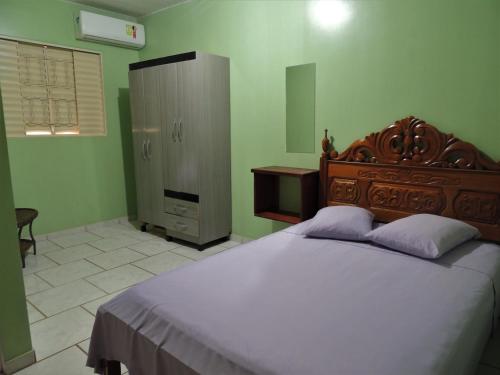 a bedroom with a large bed and a dresser at Pousada Santa Rita in Abadiânia