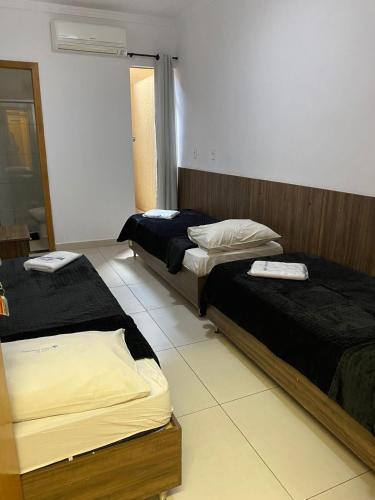 een kamer met 2 bedden in een kamer bij HOTEL E POUSADA VILLA D' MARI in Goiânia
