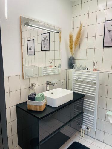 a bathroom with a sink and a mirror at Ferienwohnung Moments klimatisiert in Balingen
