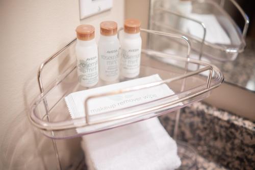 a glass rack with three bottles of soap and towels at Lagoons by Outpost Whistler in Whistler