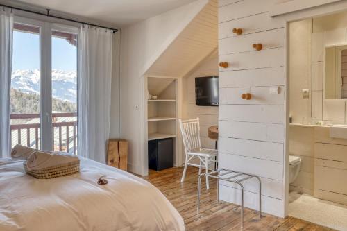 een slaapkamer met een bed en een balkon met uitzicht op de bergen bij La Féline Blanche in Saint-Gervais-les-Bains