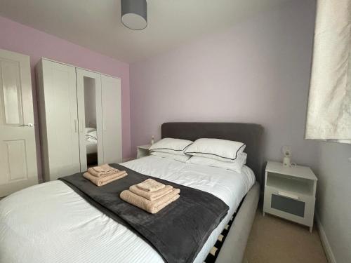 a bedroom with a bed with two towels on it at Detached family house with private garden. in Arlesey