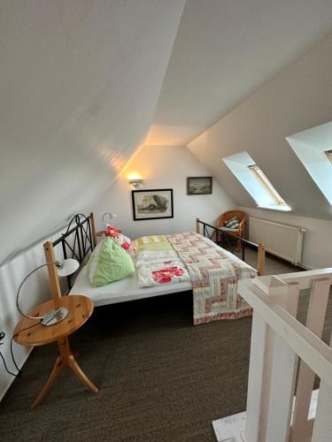 um quarto com uma cama e uma cadeira num sótão em Hafenbrise em Tönning