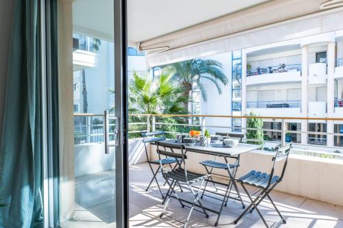 d'un balcon avec une table et des chaises. dans l'établissement 1-Br apartment in Palm Beach swimming pool, à Cannes