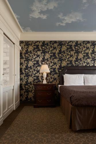 a bedroom with a bed and a table with a lamp at O.Henry Hotel in Greensboro