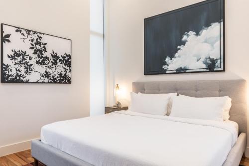 Un dormitorio con una cama blanca y una foto en la pared en Stylish & Perfectly Located Luxury 2-Bed Townhome, en Dallas