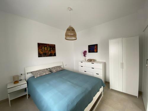 a bedroom with a blue bed and a white cabinet at Casa Monte y Mar in Morro del Jable