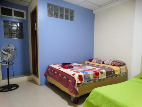 Cette chambre comprend 2 lits et un ventilateur. dans l'établissement Habitaciones El Trébol, à Playas
