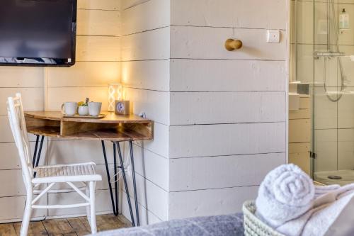 een kamer met een kleine tafel en een douche bij La Féline Blanche in Saint-Gervais-les-Bains