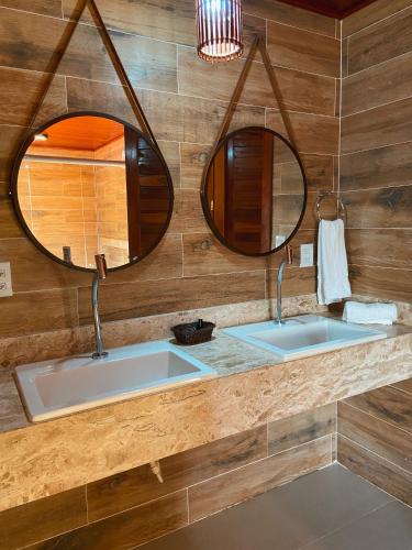 two sinks in a bathroom with two mirrors at Velho Chico in Icaraí