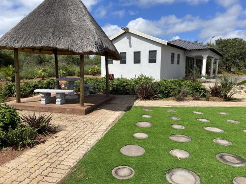 a gazebo with a picnic table and grass at Bluewave Farm Villa in Louis Trichardt