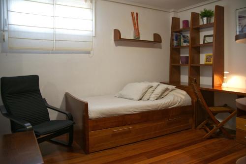 a bedroom with a bed and a desk and a chair at Villa La Perla de Sonabia in Oriñón