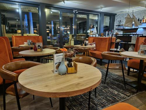 un restaurante con mesas y sillas en una habitación en Eemshotel, en Delfzijl