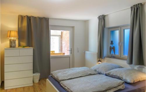 a bedroom with a bed with a window and a dresser at Nice Apartment In Loxstedt With Kitchen in Loxstedt