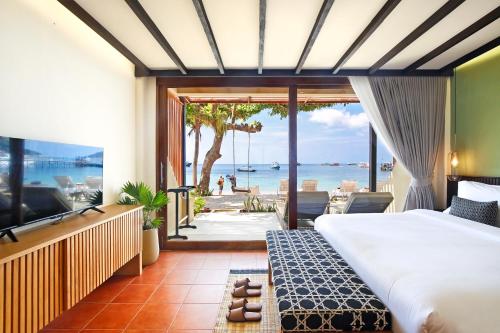 a bedroom with a bed and a view of the ocean at Lücke Boutique Hotel - Adults only in Ko Tao