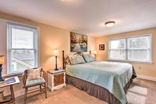 a bedroom with a bed and a desk and two windows at Central Eugene House with Updated Interior and Yard! in Eugene