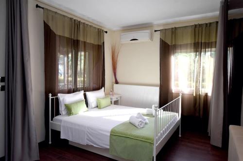 a bedroom with a white bed and some windows at Potamos Studios by GERANI in Órmos