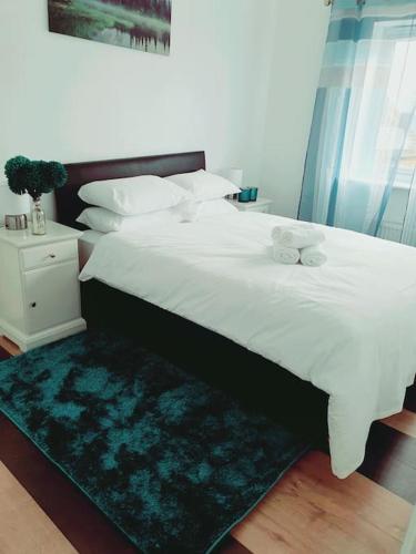 Schlafzimmer mit einem großen weißen Bett und einem grünen Teppich in der Unterkunft Spacious and Tastefully Decorated Town House In Lakeside West Thurrock Grays in West Thurrock