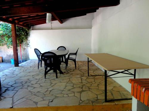 uma mesa e cadeiras num quarto com piso de pedra em B&B Quarto Violeta com Chaminé em Ramalhal