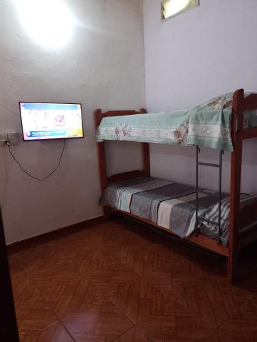 Habitación pequeña con litera y TV de pantalla plana. en Don José en Posadas