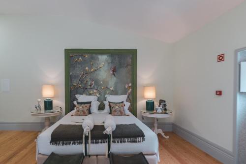 a bedroom with a large bed with a painting on the wall at Quinta de Travassinhos- Douro Valley & Spa in Santa Marta de Penaguião