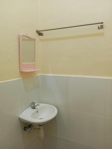 a white bathroom with a sink and a mirror at Aquing's Place in El Nido