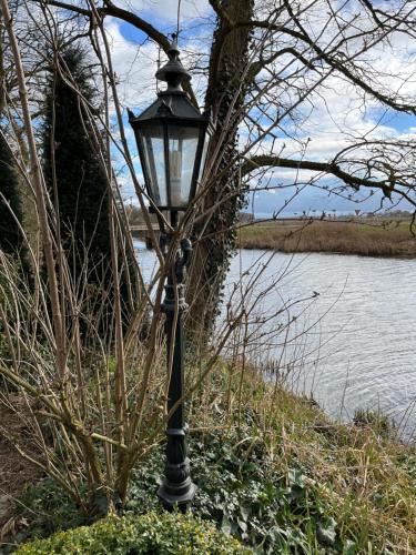 a black street light next to a body of water at domaine de la bergerie in Zuid-Beijerland