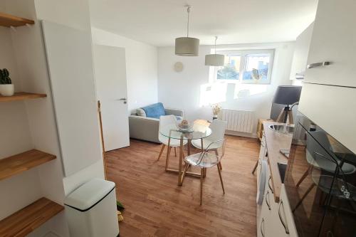 een kleine keuken en een woonkamer met een tafel en stoelen bij Le Jaures 2 - T2 - RDC in Hennebont