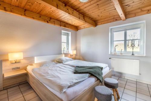 ein Schlafzimmer mit einem Bett, einem Fenster und zwei Hockern in der Unterkunft Schipp Landen Johanna in Schobüll