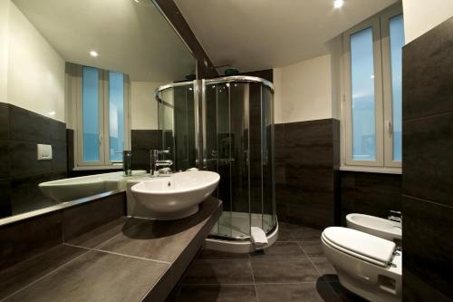 a bathroom with a sink and a shower and two toilets at Roma Naif Rooms in Rome