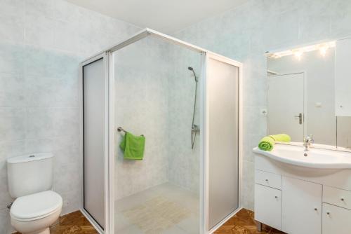 a bathroom with a shower and a toilet and a sink at Home Away From Home in Caniçal