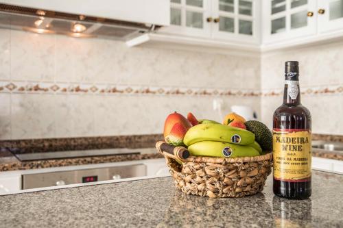 a bottle of wine sitting next to a basket of fruit at Home Away From Home in Caniçal