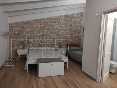 a bedroom with a bed and a brick wall at Appartamenti Mascagni in Sannicandro di Bari