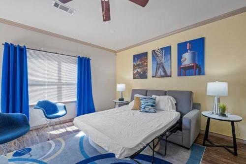 1 dormitorio con 1 cama y 1 silla azul en HEIRS VENTURES: Midtown . Near Hospitals . Pets OK* . W/D . 55” TV en Oklahoma City