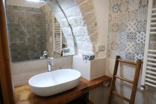 een badkamer met een witte wastafel op een houten aanrecht bij Antico Monastero in Bitonto