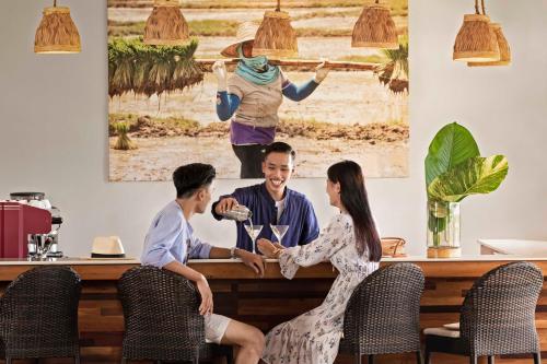 a group of people sitting around a table in a restaurant at Pimali Resort & Training Centre in Nong Khai