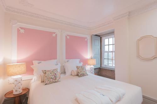 a white bedroom with a large white bed with pillows at Quinta de Travassinhos- Douro Valley & Spa in Santa Marta de Penaguião