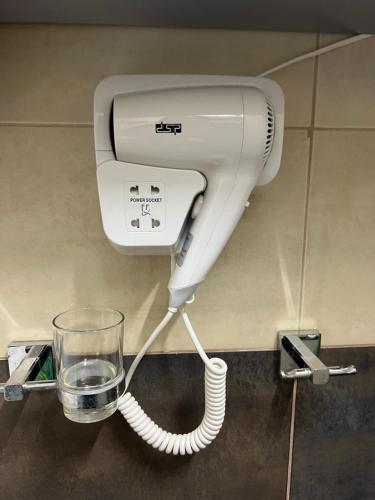 a blow dryer and a glass on a wall at Downtown Retreat "Spiranca" in Tirana
