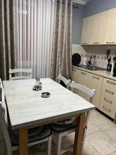 a kitchen with a white table and white chairs at Downtown Retreat "Spiranca" in Tirana