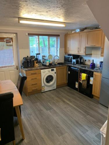 a kitchen with a washing machine and a dishwasher at Thames River Side Townhouse in Thamesmead