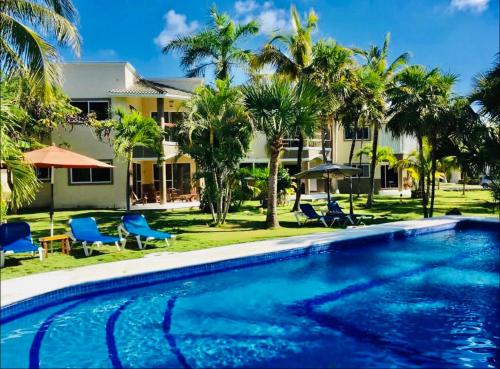 een zwembad voor een huis met palmbomen bij Mayan Riviera Jewel, Private Beach in Puerto Morelos