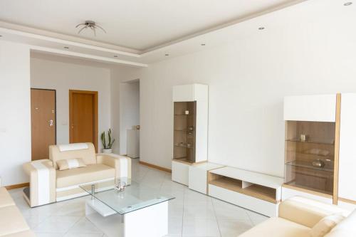 a living room with white furniture and a table at 3 bedroom apt, Exterior POOL , Cidadela - LCGR in Praia