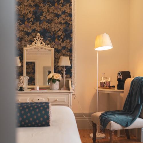 a room with a mirror and a chair and a dresser at Quinta de Travassinhos- Douro Valley & Spa in Santa Marta de Penaguião