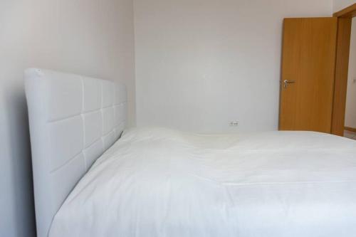 a white bed in a white room with at 3 bedroom apt, Exterior POOL , Cidadela - LCGR in Praia