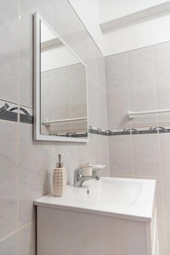a white bathroom with a sink and a mirror at 3 bedroom apt, Exterior POOL , Cidadela - LCGR in Praia