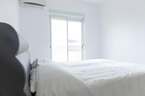 a white bed in a room with a window at 3 bedroom apt, Exterior POOL , Cidadela - LCGR in Praia
