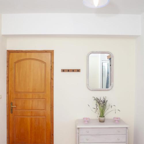 a room with a wooden door and a mirror at Mairoula apartments! in Koroni