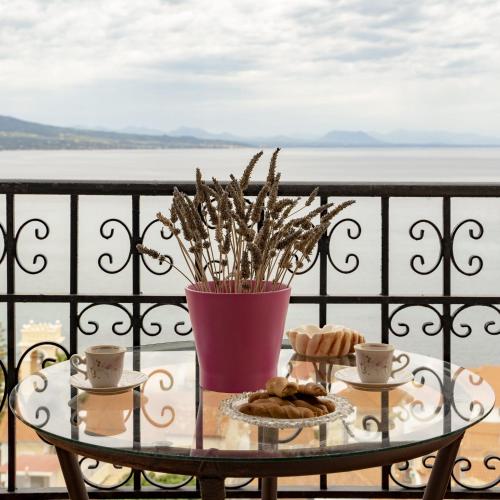 a table with cookies and a vase on a balcony at Mairoula apartments! in Koroni