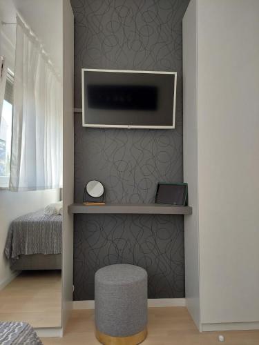 a room with a tv and a stool and a bed at Perla di Zara in Zadar